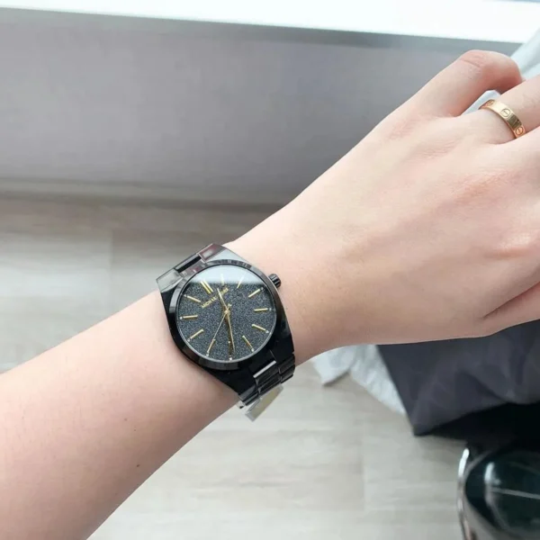 michael-kors-mk6625-femme-cadran-noir-acier-noir-portee.webp Montre Femme Michael Kors MK6625 Channing Acier Noir Cadran Pailleté